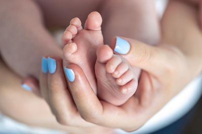 mamma che tiene in mano piedini di neonato mamma che tiene in mano piedini di neonato